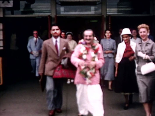 Idlewild Airport : Meher Baba outside the airport with Eruch Jessawala & Marion Florsheim ( R ). Ella Winterfeldt ( behind ) look on. Image captured by Anthony Zois from a film by Sufism Reoriented.