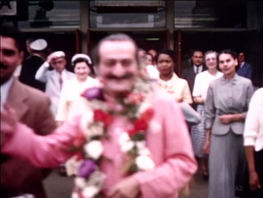Idlewild Airport : Meher Baba greeted by his entourage outside the airport.Jean Shaw ( L ), Beryl Williams ( C ) & Ella Winterfeldt ( R ) look on. Image captured by Anthony Zois from a film by Sufism Reoriented.
