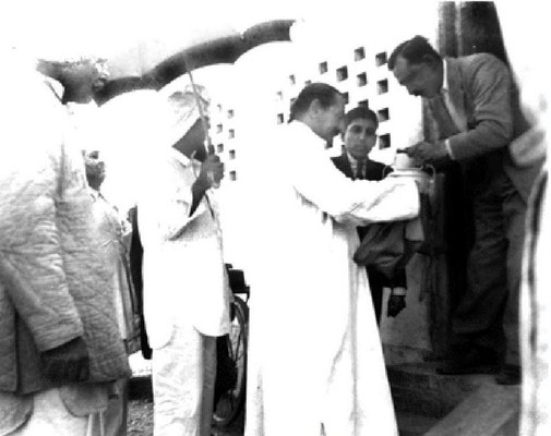 New Life- Baba accepting bhiksha from Keki Nalavala, Elcha Mistry looking on.