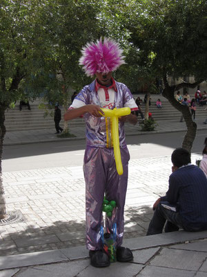 Ein Clown formt lustige Figuren aus Ballonen. (Plaza Murillo)