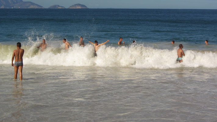 Eingeborene Jungmänner vernügen sich in den Wellen. (Strand von Copacabana)