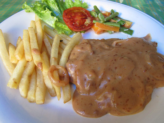 Hühnchenbrust in Pfefferrahmsoße mit Pommes und Salatgarnitur.