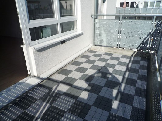 Südost-Balkon mit Schachbrettboden und Blick in den begrünten Innenhof