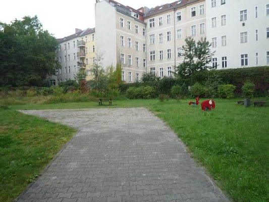 Begrünter Innenhof mit gemeinschaftlicher Grünfläche und Kinderspielplatz
