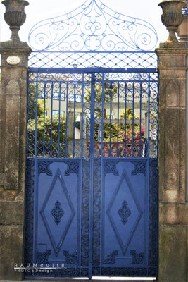 PT Blaues Schmiedeeisen-Tor vor Blumen