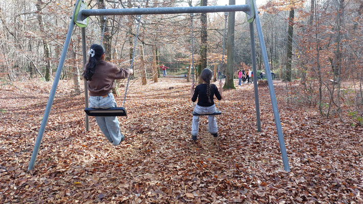 Kinder schaukeln im Wald