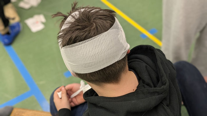Ein Schüler hat einen Verband um den Kopf.