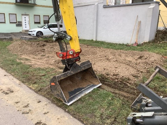 Ein Bagger gräbt den Acker aus.