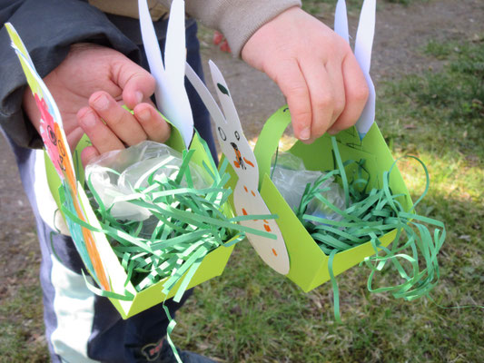Kinder halten zwei Osternester hoch.