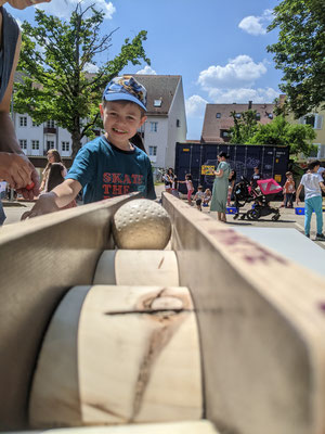 Ein Kind spielt mit einer Kugelbahn.