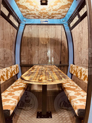 télécabine CWA bleu 8 places aménagée pour manger sur terrasse en hiver avec un thème décoration montagne
