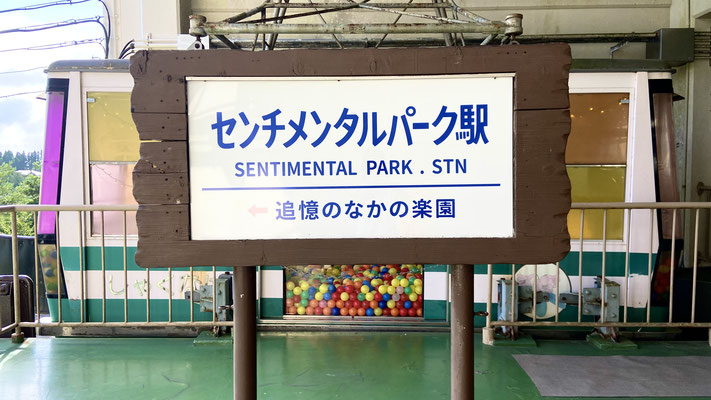作品タイトルを掲げた駅の看板。元の看板のデザインに似せて作ったオマージュである。
