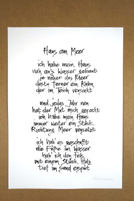 Vollansicht Kalligrafie „Haus am Meer“ Tusche auf Papier vor Hintergrund einer Tischplatte