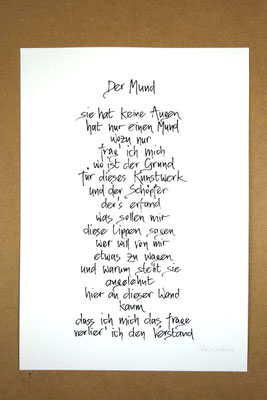 Vollansicht Kalligrafie „Der Mund“ Tusche auf Papier vor Hintergrund einer Tischplatte
