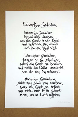 Vollansicht Kalligrafie „Lebendige Gedanken“ Tusche auf Papier vor Hintergrund einer Tischplatte