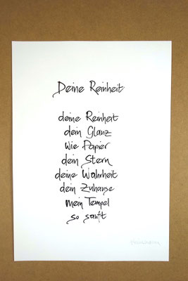 Vollansicht Kalligrafie „Deine Reinheit“ Tusche auf Papier vor Hintergrund einer Tischplatte