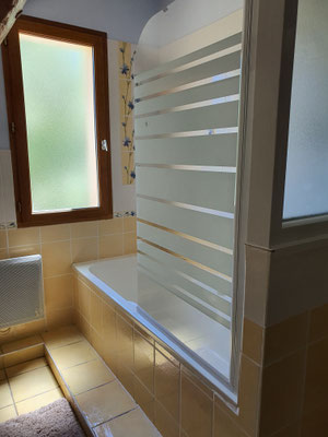 Notre salle de bain mansardée avec baignoire et pare-douche et une fenêtre donnant sur le jardin