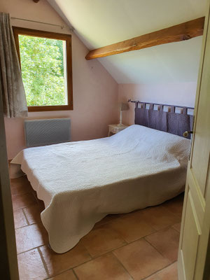 A l'étage, une deuxième chambre de notre gîte avec un lit de 160 avec ses poutres et murs en pierre et de sa fenêtre donnant sur notre jardin