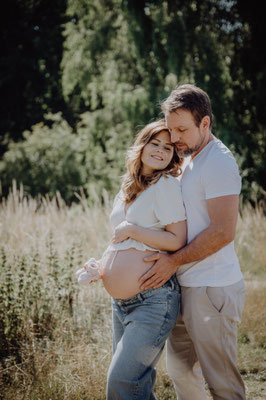 Babybauch in der Natur mit dem werdenden Papa