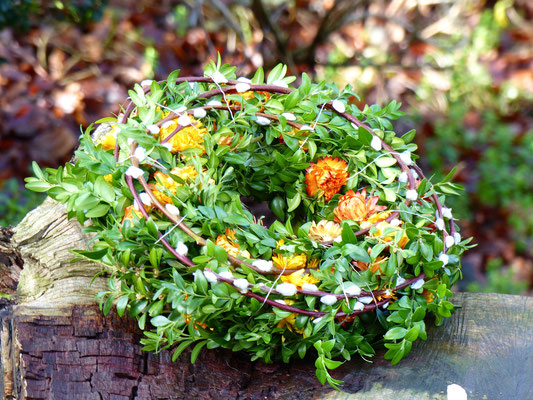 Buchsbaumkranz mit Weidenkätzchen und orangenen Strohblumen