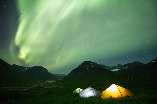 The aurora glowing overhead whilst camping in the Rapa valley of Sarek national Park, Swedish Lapland.