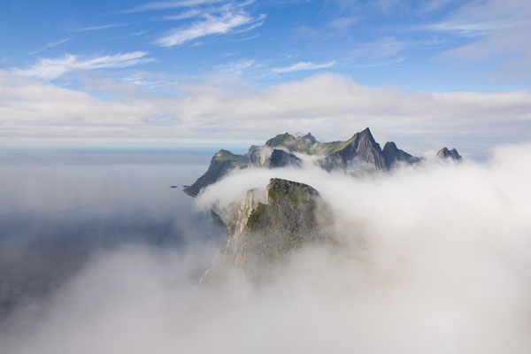 Fog rolls over the mountains of Senja island seen from the summit of Segla, northern Norway.