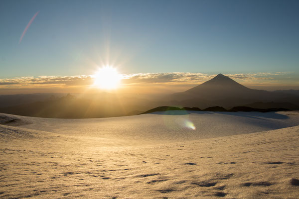 Sunrise over the snow-filled summit crater of Volcan Quetrupillan, Chilean Patagonia.