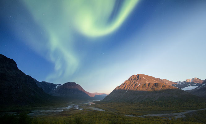 A photo blend of evening light and the aurora glowing above the Rapa valley in Sarek national park, Swedish Lapland.