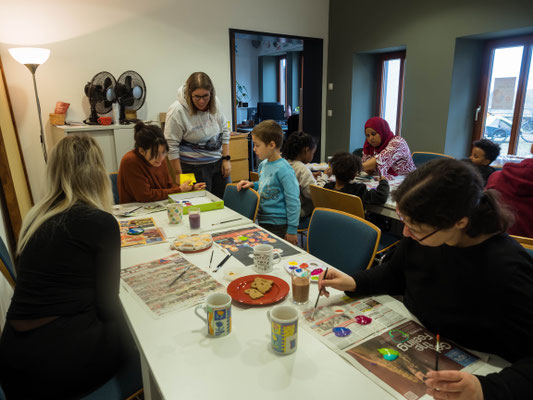Kinder am Tisch, die Herzen bemalen 