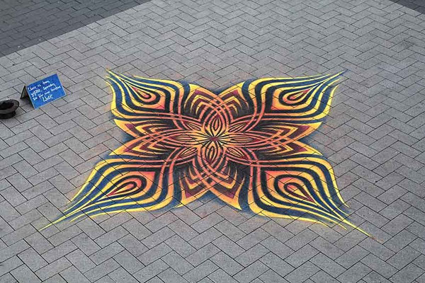 Pflastermalerei mit Kreiden, Mandala in Rot.