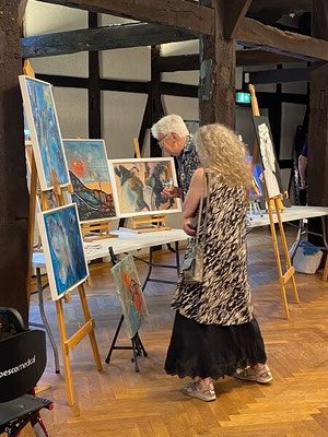 Manche Kunstliebhaber:Innen schauen ganz genau hin, um das Geheimnis der Kunst zu lüften