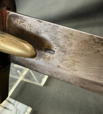 Lame courbe à dos plat et pans creux, portant un poinçon au faisceau de licteur
