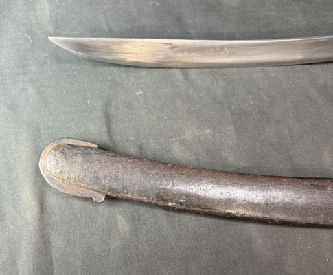 Lame courbe à dos plat et pans creux, portant un poinçon au faisceau de licteur