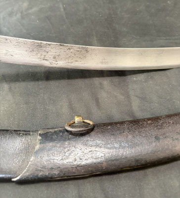 Lame courbe à dos plat et pans creux, portant un poinçon au faisceau de licteur