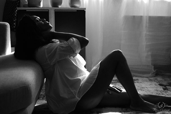 portrait d'une femme allongée en contre-jour en noir et blanc
