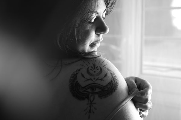 portrait femme tatouée devant une fenêtre