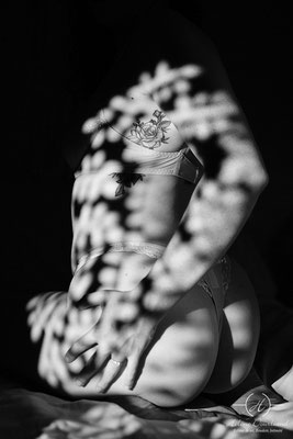 Séance photo boudoir en lingerie, magnifiée par les motifs et les formes créés par l'ombre portée