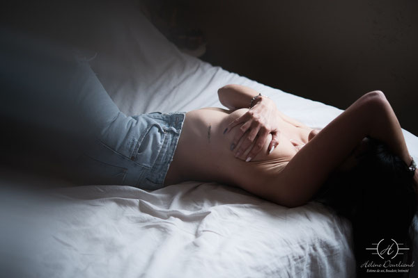 femme en jean's allongée sur un lit 