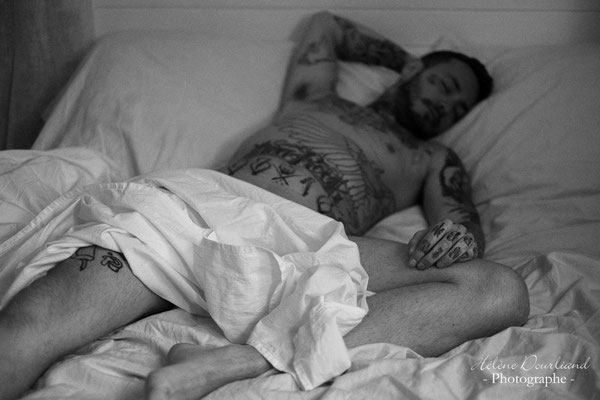 Expérience de boudoir en noir et blanc, explorant la masculinité à travers des poses artistiques de nu masculin