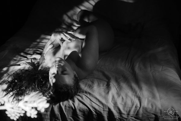 Séance de photographie boudoir en noir et blanc, mettant en avant la sensualité de la lingerie à travers des ombres délicates