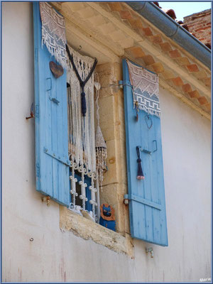 Fenêtre décorée aux volets bleus à Talmont-sur-Gironde (Charente-Maritime)