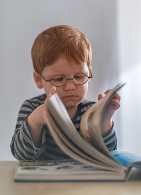 Natuerliche Kitafotos Junge liest ein Buch