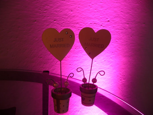 Zwei Deko-Herzen, im Hitergrund magentafarbenes Uplighting