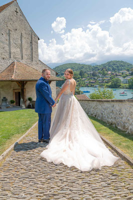 Brautpaar Hand  in  Hand im Berner Oberland vor der Schlosskirche in Spiez