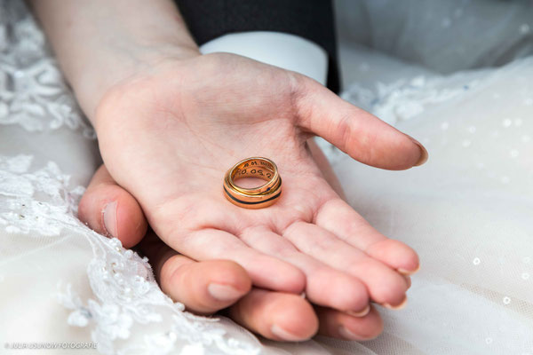 Eheringe in den Händen von Braut und Bräutigam