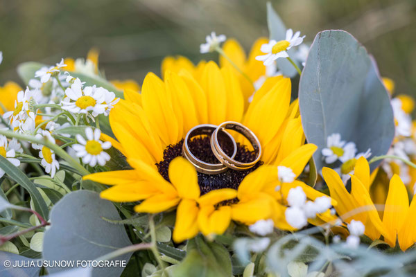 Brautstrauss aus Sonnenblumen mit Eheringen in der Blüte