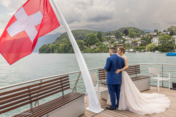 Brautpaar auf dem Schiff mit schweizer Flagge, auf dem Thunersee in der Schweiz, Berner Oberland 