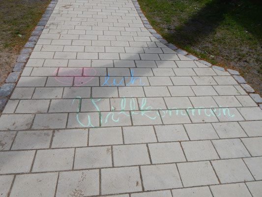 Herzlich Willkommen als Kreideschrift auf Gehweg