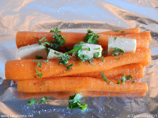 Karotten, Butter und frische Kräuter auf Alufolie