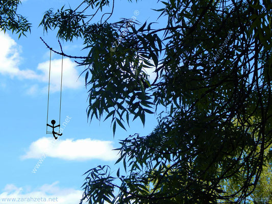 Kleines Strichmännchen schaukelt an einem Baumzweig unter blauem Himmel